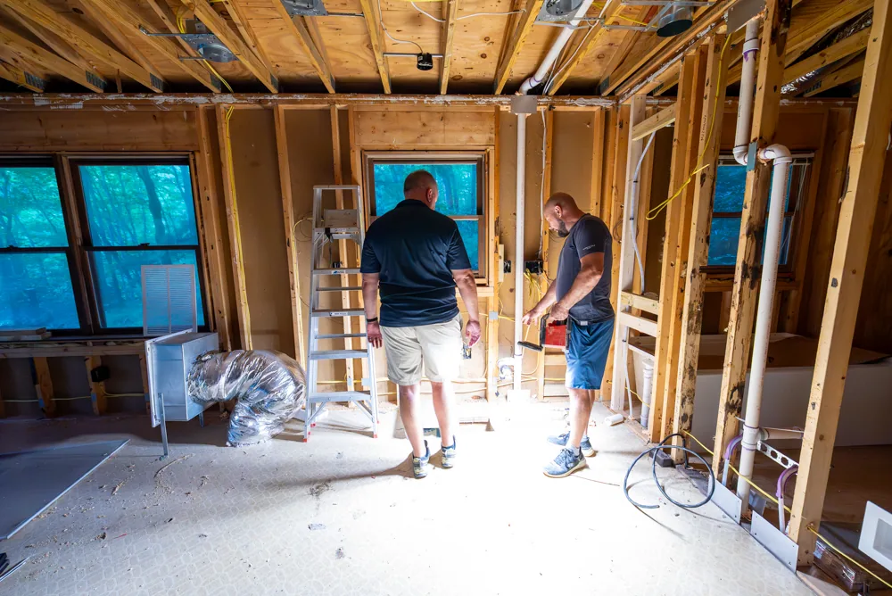 Interior renovation in progress with exposed framing and rough-ins
