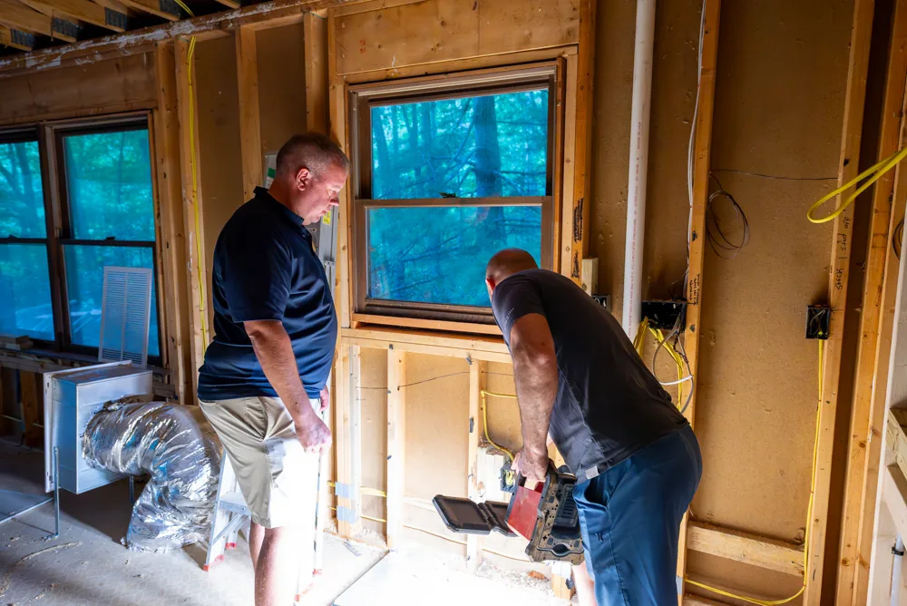 Brad Currin inspecting walls and framing during an interior renovation